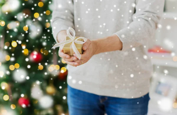 Primer plano del hombre con regalo de Navidad en casa —  Fotos de Stock