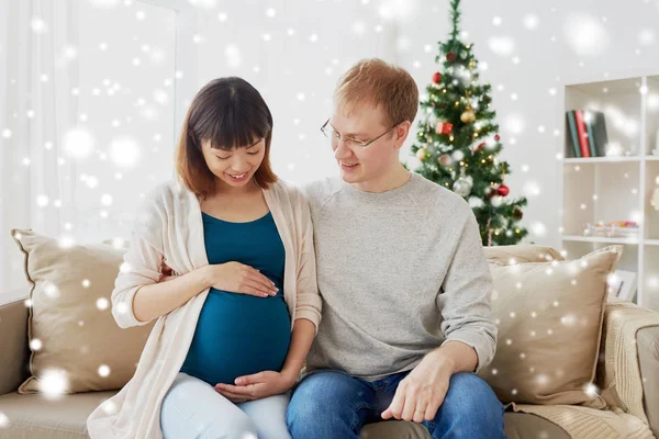 Esposa embarazada con marido en casa en Navidad — Foto de Stock