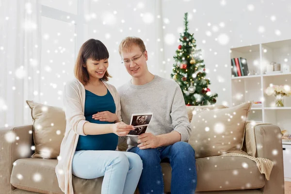 Casal feliz com imagens de ultra-som no Natal — Fotografia de Stock