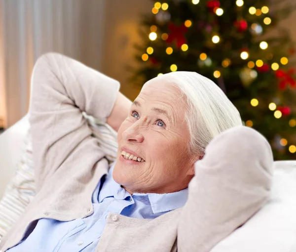 Lycklig senior kvinna vilar på soffan på jul — Stockfoto