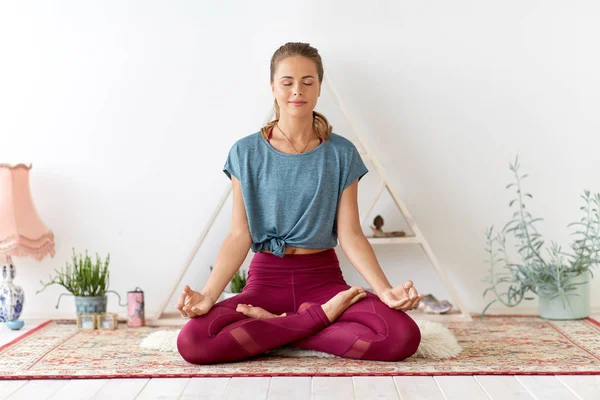 Nilüfer çiçeğiyle meditasyon yapan kadın yoga stüdyosunda poz veriyor. — Stok fotoğraf