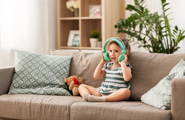 Ruda dziewczynka w słuchawki do słuchania muzyki — Zdjęcie stockowe