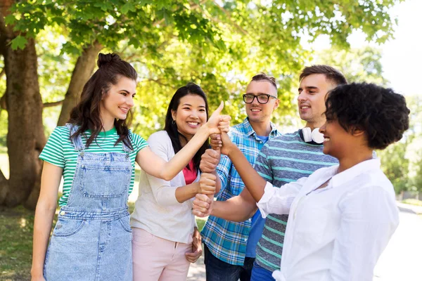 Amigos felizes fazendo polegares no parque — Fotografia de Stock