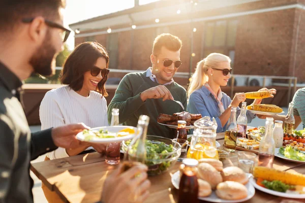 Щасливі друзі їдять на вечірці барбекю на даху — стокове фото