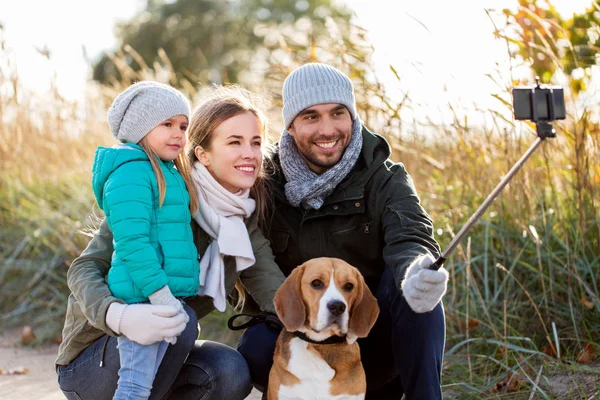 Famille heureuse avec chien prenant selfie en automne — Photo