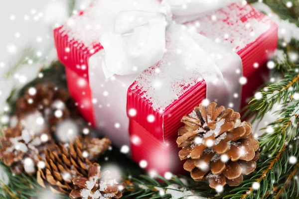 Perto de presente de Natal e grinalda de abeto na neve — Fotografia de Stock