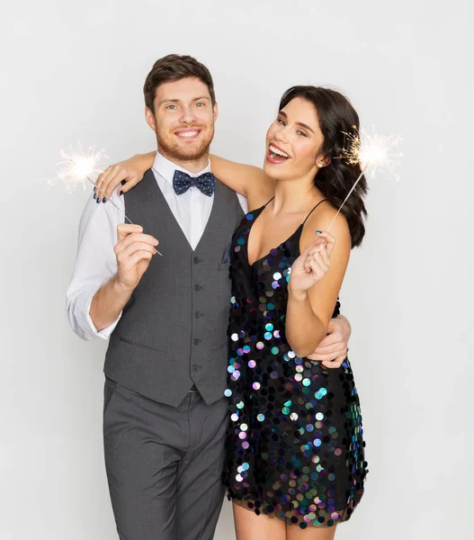 Casal feliz com sparklers na festa — Fotografia de Stock