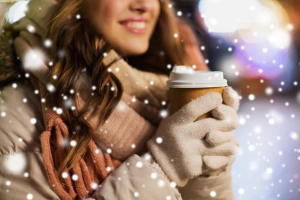 Happy woman with coffee over christmas lights — Stock Photo, Image