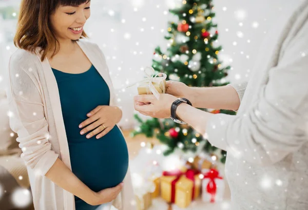 Marido dando presente de Natal à esposa grávida — Fotografia de Stock