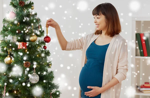 Donna incinta decorazione albero di Natale a casa — Foto Stock