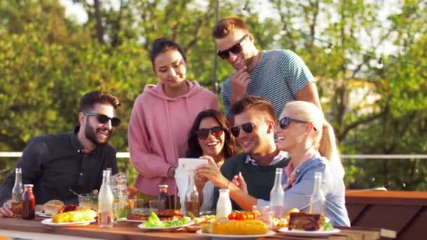 Happy friends using smartphone at rooftop party — Stock Video