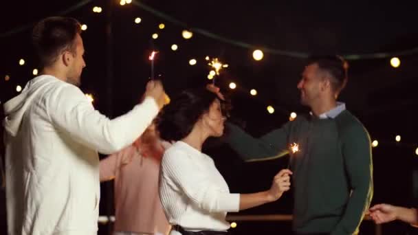 Друзі з блискітками танцюють на вечірці на даху — стокове відео