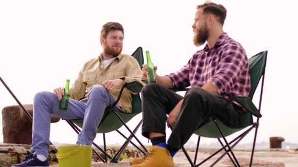 Happy friends fishing and drinking beer on pier — Stock Video