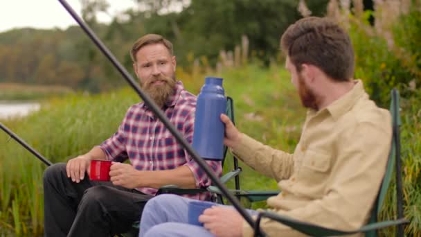 Amigos de la pesca y beber té del termo — Vídeo de stock