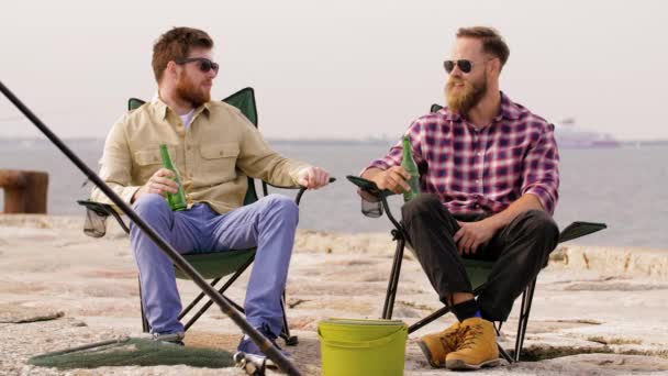 Gelukkig vrienden vissen en bier drinken op pier — Stockvideo