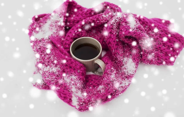 Tea or coffee mug and winter scarf on snow — Stock Photo, Image