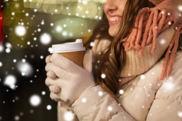 Gelukkige vrouw met koffie over Kerstverlichting — Stockfoto