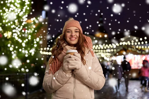 Gelukkig jonge vrouw met koffie op kerstmarkt — Stockfoto