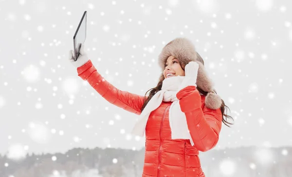 Vrouw in winter bont muts met tablet pc buitenshuis — Stockfoto