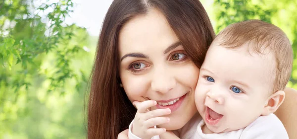 Moeder met baby over groene natuurlijke achtergrond — Stockfoto