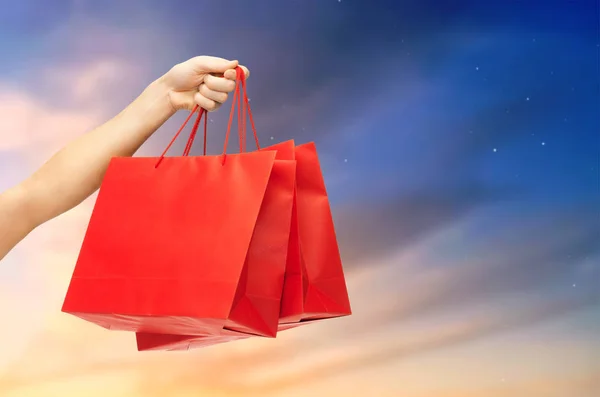 Erkek el Kırmızı alışveriş torbaları tutarak yakın çekim — Stok fotoğraf