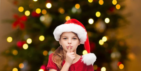 Girl in santa hat over christmas tree lights — Stock Photo, Image