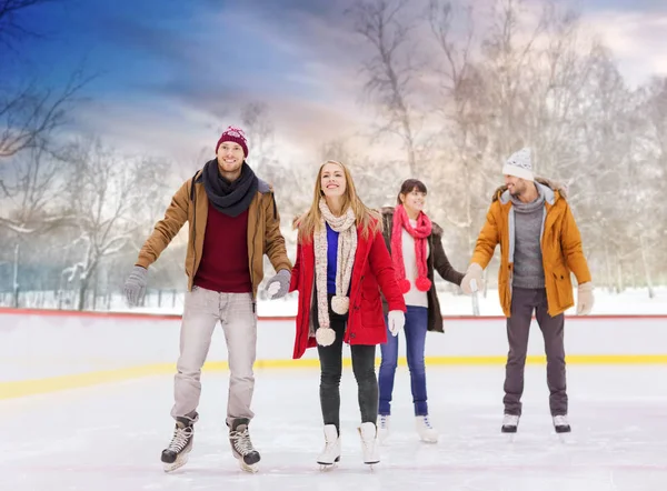 Happy friends on outdoor skating rink — Stock Photo, Image