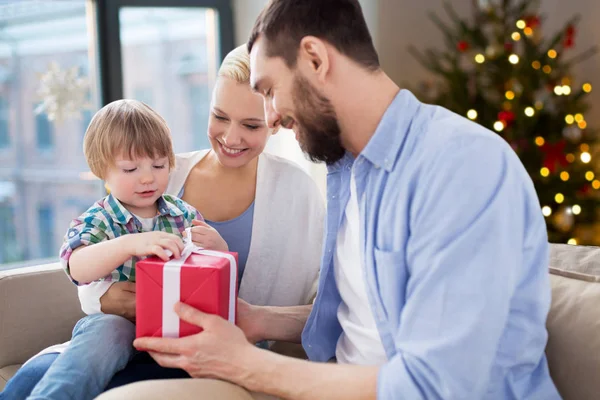 Happy family with christmas gift at home — Stock Photo, Image