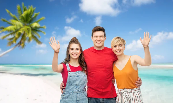 Amigos felices abrazándose sobre fondo de playa — Foto de Stock