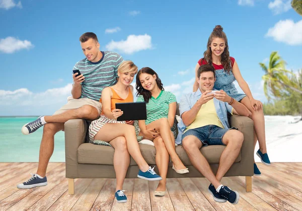 Freunde mit Tablet-PC und Smartphones am Strand — Stockfoto