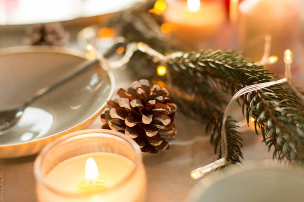 Cono de pino y velas ardiendo en la mesa de Navidad —  Fotos de Stock