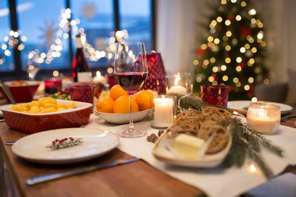 Glas rode wijn en eten op kersttafel — Stockfoto