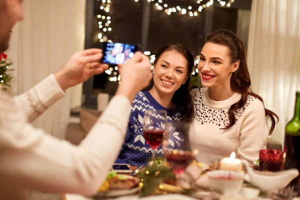 Amigos que têm jantar de Natal e tirar fotos — Fotografia de Stock