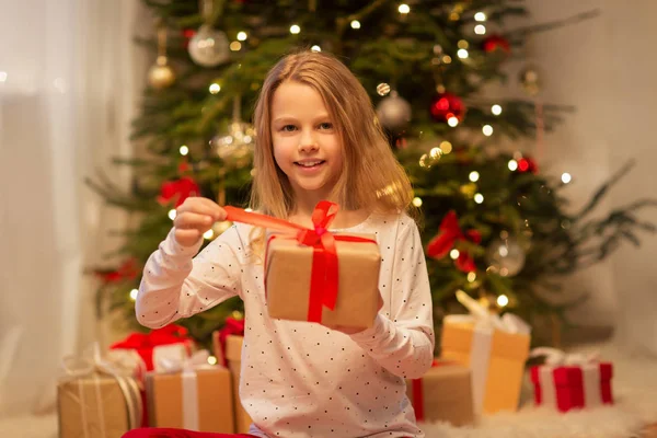 Leende flicka med julklapp hemma — Stockfoto