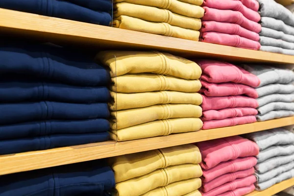 Primer plano de estantes con ropa en la tienda de ropa — Foto de Stock