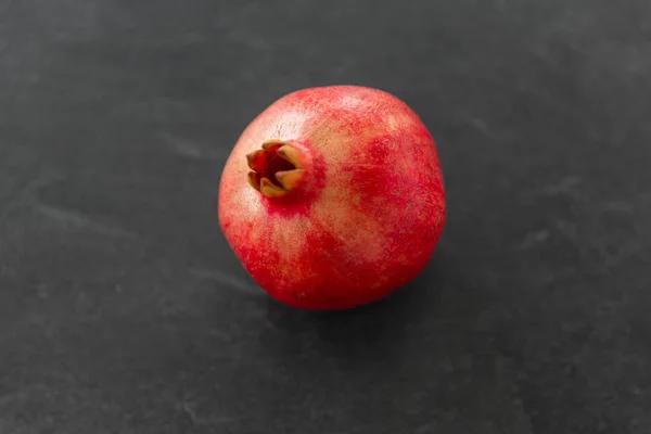 Close up of pomegranate on stone table — Stock Photo, Image