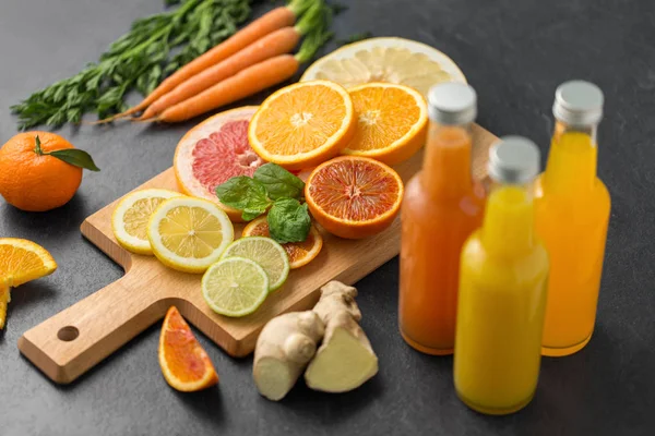 Bouteilles en verre de jus de fruits sur dessus de table en ardoise — Photo