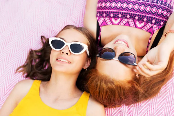 Piknik battaniyesi üzerinde güneş gözlüklü genç kızlar — Stok fotoğraf
