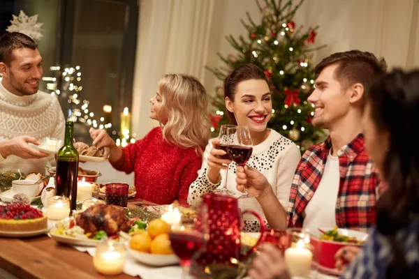 Šťastní přátelé mají vánoční večeři doma Stock Snímky
