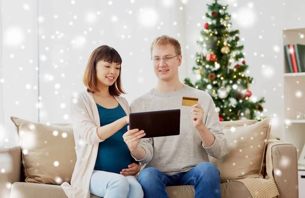 Mann und schwangere Frau kaufen zu Weihnachten online ein — Stockfoto