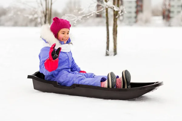 Щаслива маленька дівчинка на санчатах на відкритому повітрі взимку — стокове фото