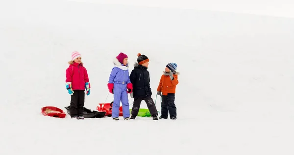 Niños pequeños felices con trineos en invierno —  Fotos de Stock