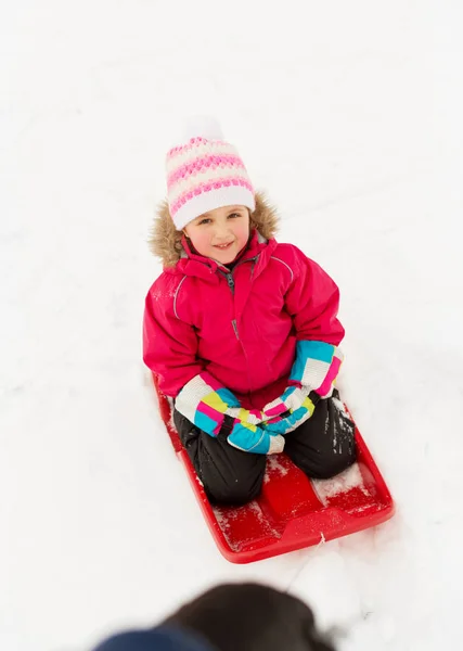 Kışın açık havada kızak üzerinde mutlu küçük kız — Stok fotoğraf