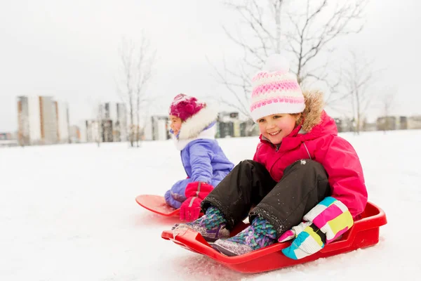 Joyeuses petites filles sur luges en plein air en hiver — Photo