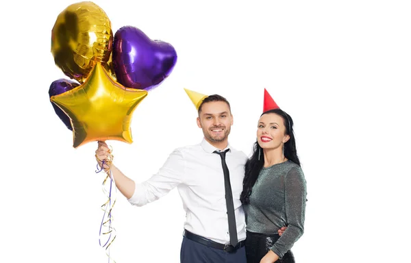 Couple heureux avec casquettes de fête et ballons — Photo