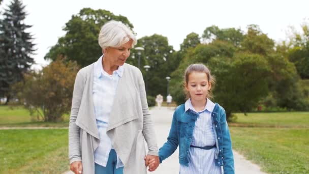 Бабушка и внучка гуляют в парке — стоковое видео