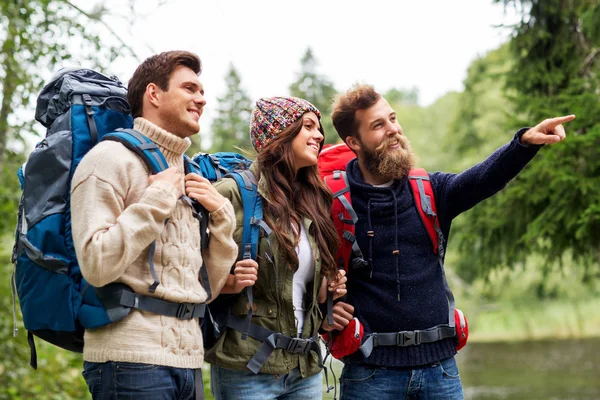 Happy friends or travelers with backpacks hiking — Stock Photo, Image