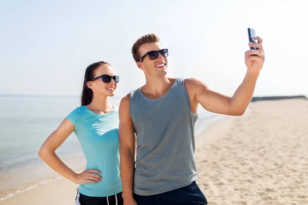 Paar macht Selfie mit Smartphone am Strand — Stockfoto