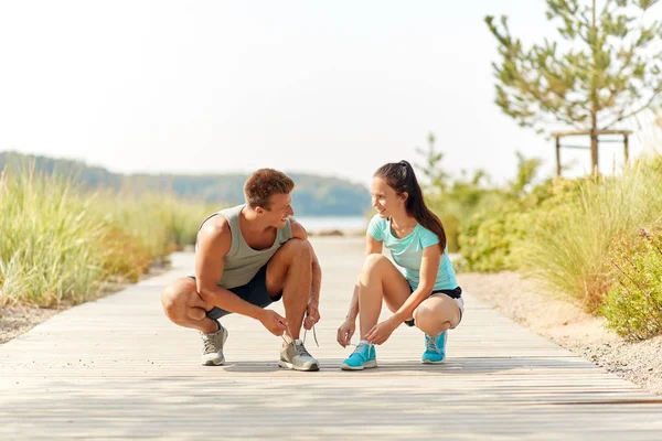 Couple de joggeurs attacher des chaussures lacets — Photo