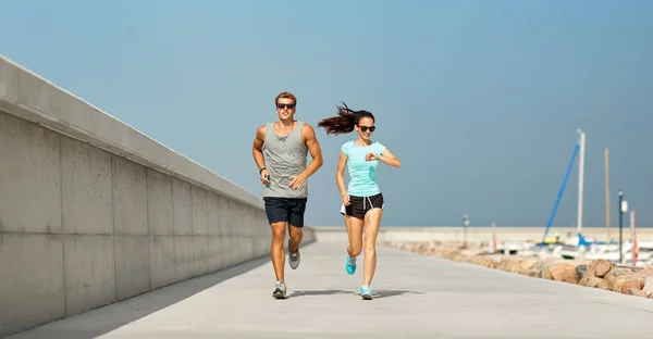 Paar in sporten kleren buitenshuis uitvoeren — Stockfoto